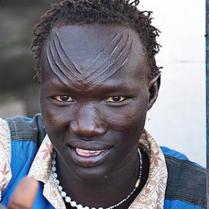 A Dinka man (Nilotic). Genome analysis indicates that the Dinka, Nuer, Shilluk and other northern Nilotes of the Nile Valley predominantly bear the ancient Nilo-Saharan ancestral component. However, these northern Nilotic individuals also possess significant Eurasiatic admixture (i.e., European Steppe and ancient East Asian components), which was likely derived from early contacts with the Eastern Libyans.